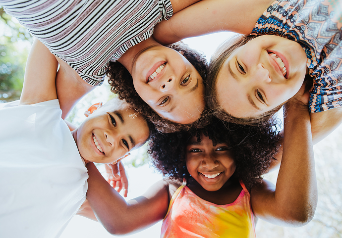Kids gathered in a circle outside and having a great time.