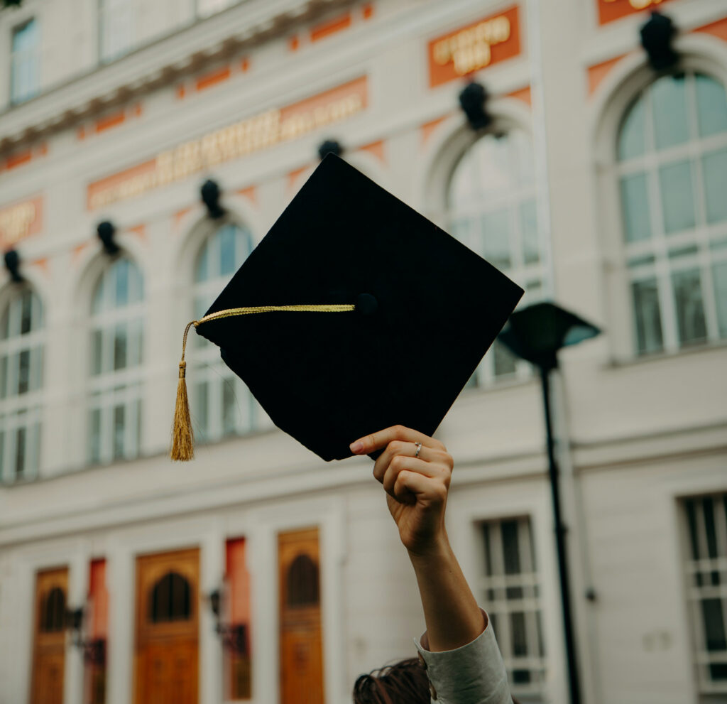 A Person Holding Up A Graduation Cap